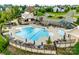 Aerial view of the community pool with lounge chairs, umbrellas, and a playground, perfect for summer fun at 5431 Meadowcroft Way, Fort Mill, SC 29708