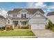 Charming two-story home featuring a well-manicured lawn, stone accents and a two car garage at 5431 Meadowcroft Way, Fort Mill, SC 29708