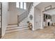 Elegant foyer with wood-look floors, statement mirror, staircase with iron spindles and a decorative plant at 5431 Meadowcroft Way, Fort Mill, SC 29708