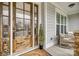 Charming front porch with detailed wooden front door, stone and siding accents, and cozy seating area at 5431 Meadowcroft Way, Fort Mill, SC 29708
