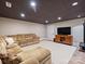 Spacious basement showcasing a large sofa, entertainment center with a TV, and recessed lighting at 5824 Preston Ln, Charlotte, NC 28270