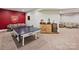 Basement game room with a ping pong table, bar, and adjacent seating area for entertaining guests at 5824 Preston Ln, Charlotte, NC 28270
