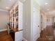 Hallway with built in bookcases and wooden floors, leading to other rooms in the house at 5824 Preston Ln, Charlotte, NC 28270