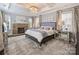 Comfortable main bedroom showcasing a stone fireplace, tray ceiling, and stylish decor at 5824 Preston Ln, Charlotte, NC 28270