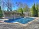 Beautiful swimming pool featuring a stone waterfall and surrounded by lush landscaping and a brick paver patio at 5824 Preston Ln, Charlotte, NC 28270