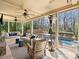 Relaxing covered porch featuring ceiling fans, stylish furniture, and a picturesque view of the backyard and pool at 5824 Preston Ln, Charlotte, NC 28270