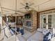 Cozy porch area with a stone fireplace, comfortable seating, and ceiling fans, perfect for outdoor enjoyment at 5824 Preston Ln, Charlotte, NC 28270