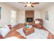 Cozy living room with a brick fireplace, leather seating, wood floors, and a neutral color palette at 6411 Boykin Spaniel Rd, Charlotte, NC 28277