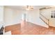 Spacious living room featuring staircase, neutral colors, and open access to the second floor and other rooms at 7712 Grapetree Ct, Charlotte, NC 28215