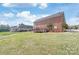 Large brick home with a spacious deck overlooking a well-maintained backyard at 7925 Tottenham Dr, Harrisburg, NC 28075