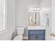 Powder room features a blue vanity with marble countertop and modern fixtures at 7925 Tottenham Dr, Harrisburg, NC 28075