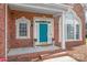 Close-up of brick house with blue door, portico entrance, and manicured landscaping at 7925 Tottenham Dr, Harrisburg, NC 28075