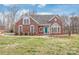Charming brick home with a well-manicured lawn, blue front door, and bright windows at 7925 Tottenham Dr, Harrisburg, NC 28075