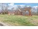Charming brick home featuring a well-manicured lawn and inviting blue front door at 7925 Tottenham Dr, Harrisburg, NC 28075