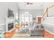 Bright, open-concept living room with fireplace, large windows, and hardwood floors at 7925 Tottenham Dr, Harrisburg, NC 28075