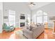 Bright, open-concept living room with fireplace, large windows, and hardwood floors at 7925 Tottenham Dr, Harrisburg, NC 28075