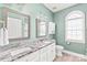 Elegant main bathroom featuring double sinks, a marble countertop, and arched windows at 7925 Tottenham Dr, Harrisburg, NC 28075