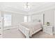 Bright main bedroom with tray ceilings, a ceiling fan, and large windows at 7925 Tottenham Dr, Harrisburg, NC 28075