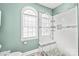 Modern glass shower with tiled walls, a built-in bench, and arched window at 7925 Tottenham Dr, Harrisburg, NC 28075