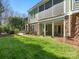 Spacious backyard with well-maintained lawn, stone accents, and a cozy covered patio area at 8416 Highgrove St, Charlotte, NC 28277