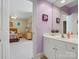 A bright bathroom featuring a white vanity with a mirror, offering a glimpse into an adjacent bedroom at 8416 Highgrove St, Charlotte, NC 28277