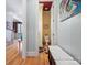 Hallway view into bathroom with toilet, light, and framed art on yellow-painted walls, along with a nearby staircase at 8416 Highgrove St, Charlotte, NC 28277