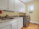 Functional laundry room with granite countertops, modern washer and dryer, and ample cabinet space at 8416 Highgrove St, Charlotte, NC 28277