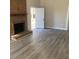 Cozy living room featuring a brick fireplace, neutral wall color, and new flooring at 8515 Mission Hills Rd, Charlotte, NC 28227