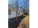Side view of home featuring classic white siding and mature trees at 8515 Mission Hills Rd, Charlotte, NC 28227