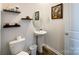 This half bath features a pedestal sink, white fixtures, and stylish decorative shelves at 9025 Remnick Dr, Gastonia, NC 28056