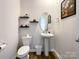 Small bathroom featuring pedestal sink, toilet, shelving and small mirror at 9025 Remnick Dr, Gastonia, NC 28056