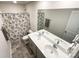 Bathroom featuring double sink vanity, large mirror, and tiled shower with decorative curtain at 9025 Remnick Dr, Gastonia, NC 28056