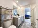 Modern bathroom with double sinks, tile floor, neutral decor, and doorway to main bedroom at 9025 Remnick Dr, Gastonia, NC 28056