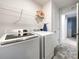 Functional laundry room with washer, dryer, shelving, and light tile flooring at 9025 Remnick Dr, Gastonia, NC 28056