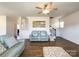 Open-concept living room with hardwood floors, ceiling fan, and stairway to second floor at 9025 Remnick Dr, Gastonia, NC 28056