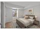 This is a bedroom that is virtually staged with a large bed and hardwood floors and a beautiful window at 9405 Old Concord Rd # G, Charlotte, NC 28213