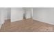 Empty bedroom with light wood floors and a door to the bathroom in the background at 9405 Old Concord Rd # G, Charlotte, NC 28213