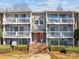 Charming condominium building with stairs leading to the red front door and a well-maintained lawn at 9405 Old Concord Rd # G, Charlotte, NC 28213