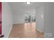 Bright, empty living room featuring wood-look floors, neutral paint, and large sliding glass doors to a balcony at 9405 Old Concord Rd # G, Charlotte, NC 28213