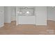 Bright living room features light wood floors and a view into the kitchenette at 9405 Old Concord Rd # G, Charlotte, NC 28213