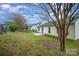 Side view of the backyard featuring a small patio, lawn, and trees providing shade and privacy at 10130 Illoria Dr, Charlotte, NC 28273