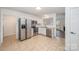 View of kitchen features stainless steel appliances, white cabinets and leads to the bright and airy living room at 10130 Illoria Dr, Charlotte, NC 28273