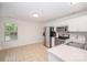 Kitchen features stainless steel appliances, white cabinets, and tile flooring by a bright, natural-lit eating area at 10130 Illoria Dr, Charlotte, NC 28273
