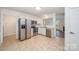 View of kitchen features stainless steel appliances, white cabinets and leads to the bright and airy living room at 10130 Illoria Dr, Charlotte, NC 28273