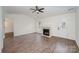 Living room features wood-look floors, a fireplace, a ceiling fan, and a door that leads to the outside at 10130 Illoria Dr, Charlotte, NC 28273