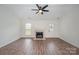 Living room features wood-look floors, a fireplace, a ceiling fan, and a door that leads to the outside at 10130 Illoria Dr, Charlotte, NC 28273