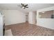 Bright living room with modern ceiling fan, fireplace, wood-look flooring, open to other rooms at 10130 Illoria Dr, Charlotte, NC 28273