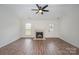 Living room features wood-look floors, a fireplace, a ceiling fan, and a door that leads to the outside at 10130 Illoria Dr, Charlotte, NC 28273