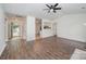 Bright living room showcasing wood floors, a ceiling fan, and access to both the entry and an open-concept kitchen at 10130 Illoria Dr, Charlotte, NC 28273