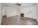 Living room features wood-look floors, a fireplace, a ceiling fan, and a door that leads to the outside at 10130 Illoria Dr, Charlotte, NC 28273